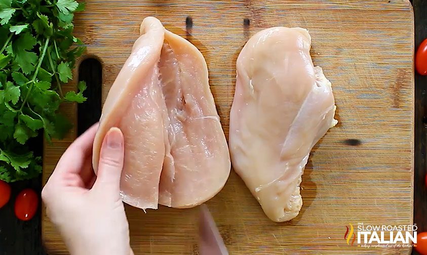 butterflied chicken breast uncooked on cutting board