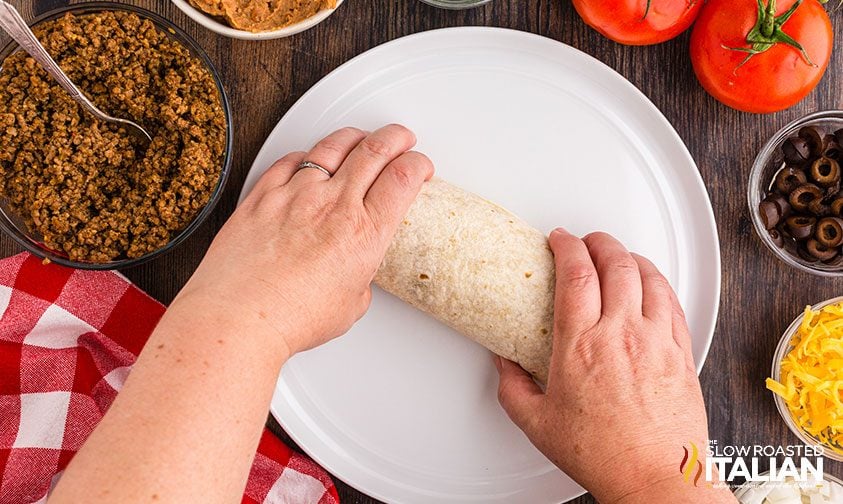 rolling a burrito on plate