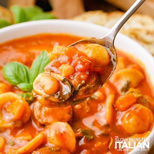 spoonful of Italian sausage soup over the bowl.