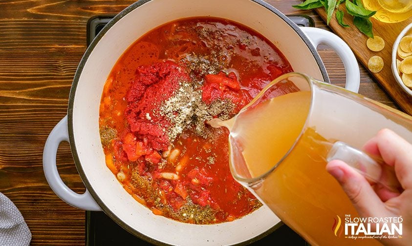 adding chicken stock to italian soup with sausage