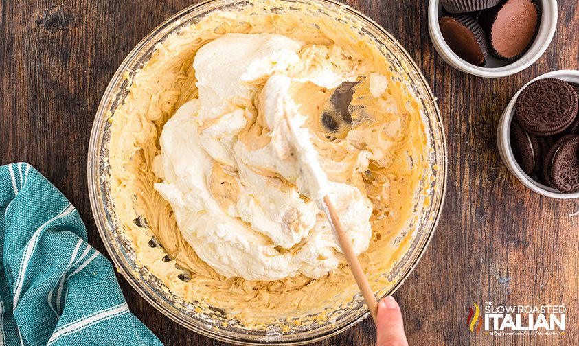 folding whipped cream into peanut butter cheesecake batter