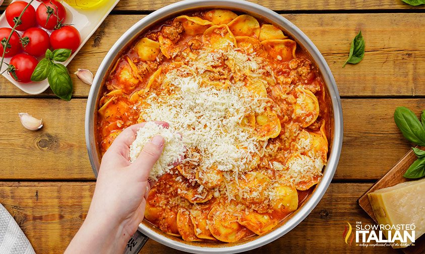 sprinkling parmesan cheese into a skillet meal