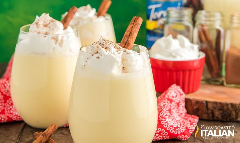 three glasses of non alcoholic eggnog topped with whipped cream