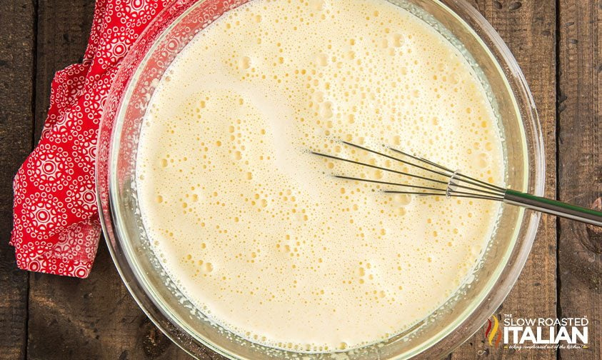 whisking eggnog recipe ingredients in a bowl