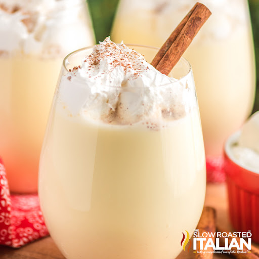 Christmas drink in a glass with whipped cream and cinnamon stick