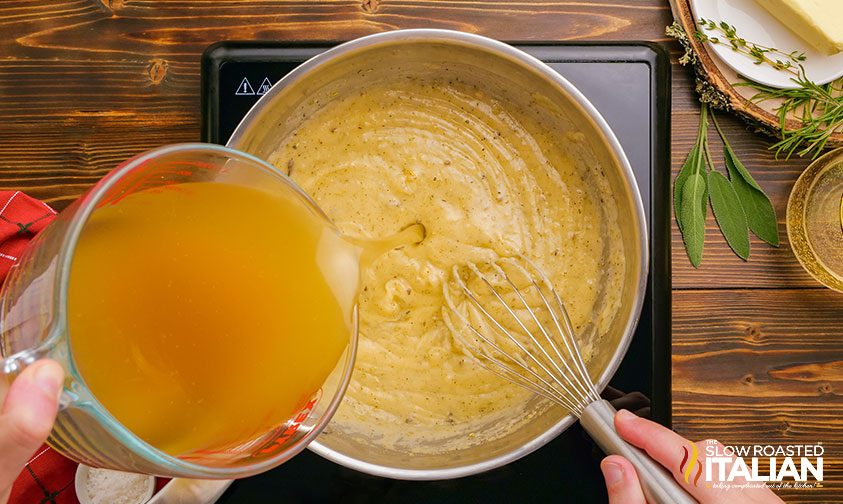 pouring chicken stock into pot of roux