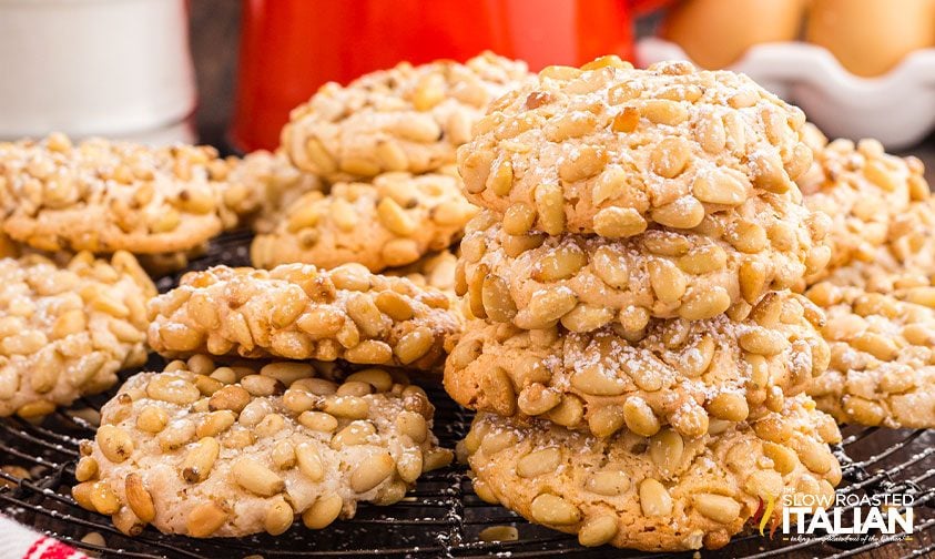 italian pine nut cookies piled on a cooling rack