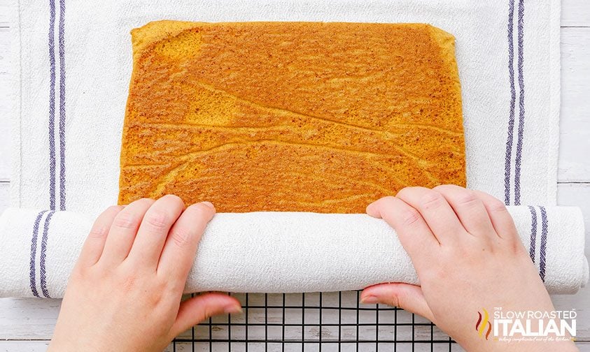 rolling pumpkin cake in kitchen towel
