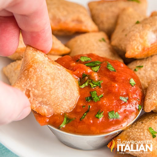 dipping fried appetizer in marinara sauce