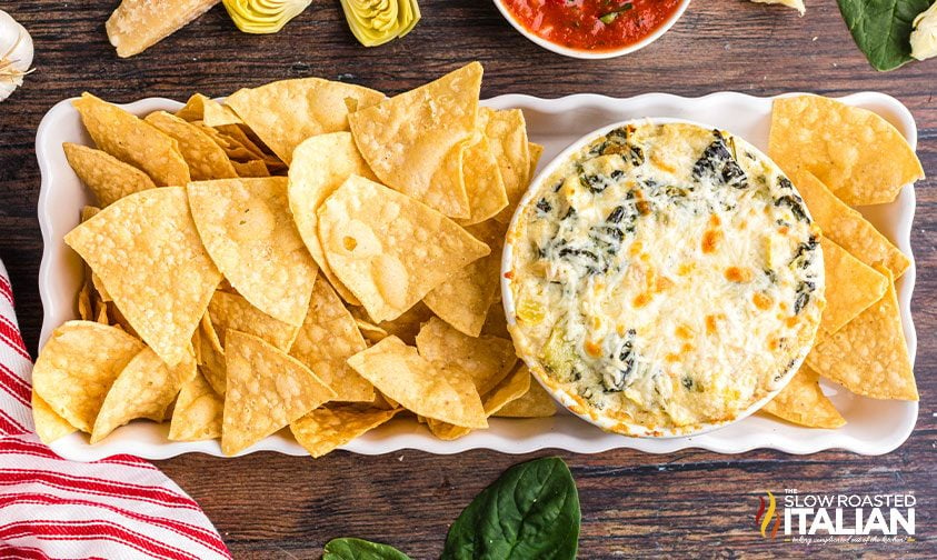 applebees artichoke spinach dip on a serving tray with tortilla chips