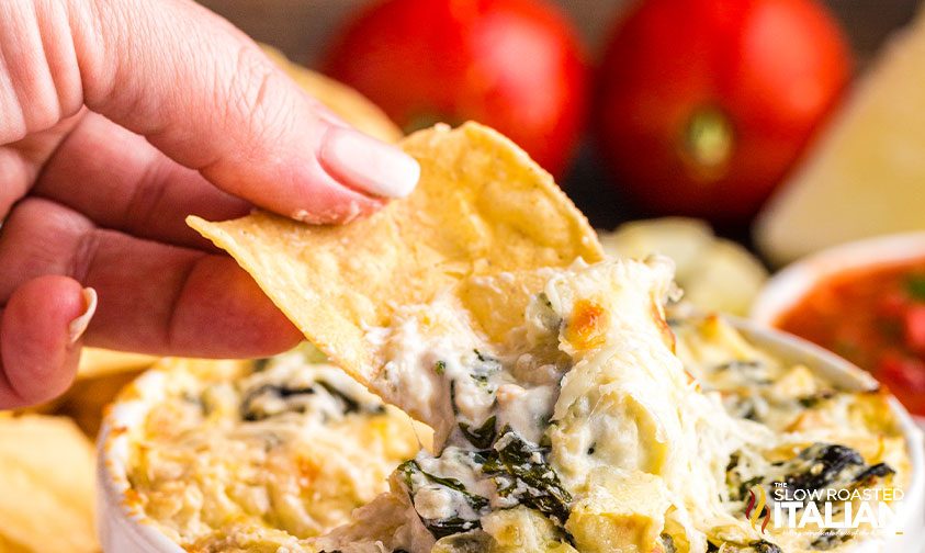 scooping up cheesy dip with corn tortilla chip