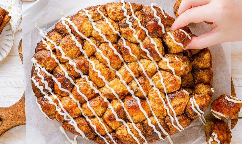 removing piece of monkey bread from loaf