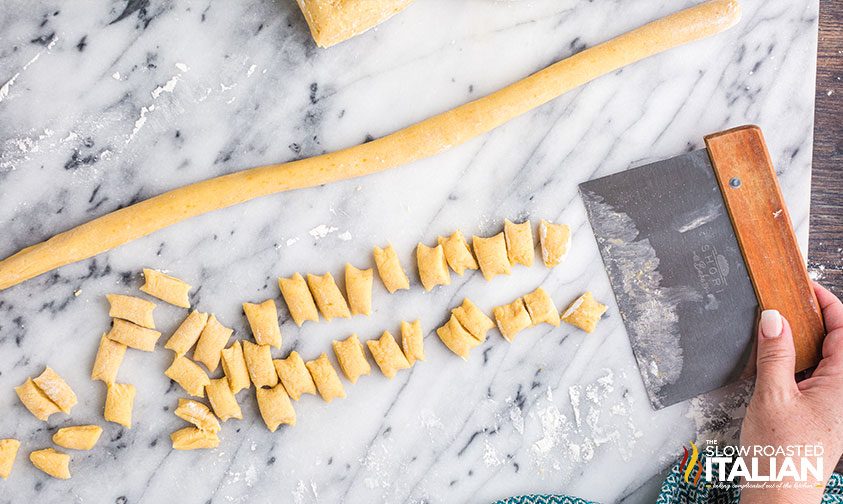 pastry dough cut into pieces on marble slab