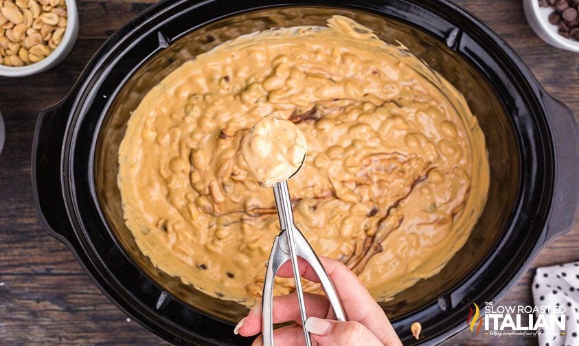 scooping peanut butter candy mixture from slow cooker
