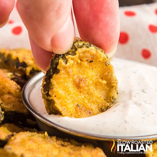 dipping fried pickle into white sauce