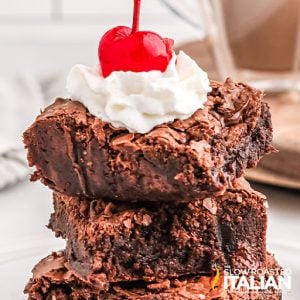 chewy brownies topped with whipped cream and cherry