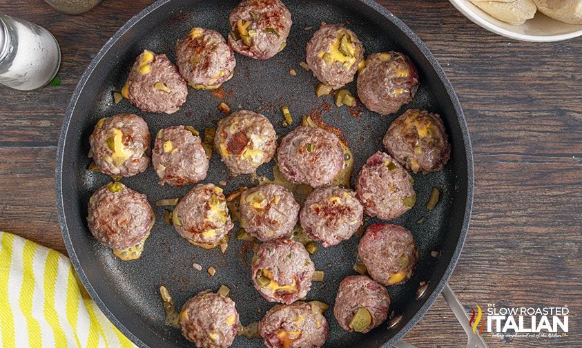 cheesy meatballs cooking in skillet