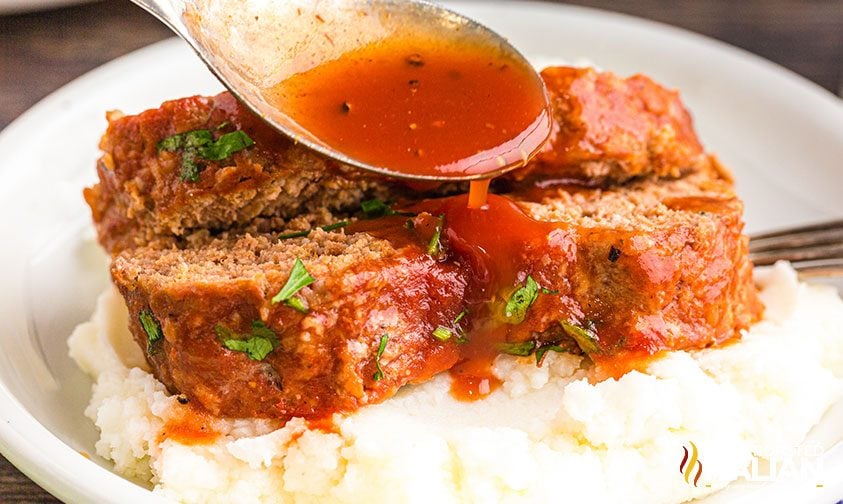 spooning sauce over slices of meatloaf made with oatmeal