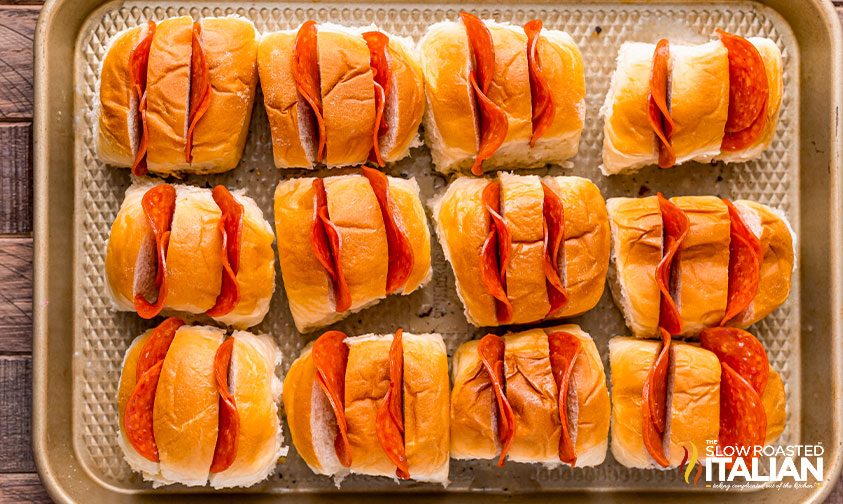hawaiian rolls stuffed with pepperoni on baking sheet