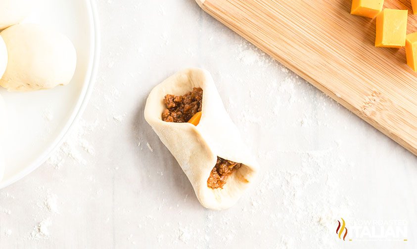 wrapping bread dough around cheesy ground beef