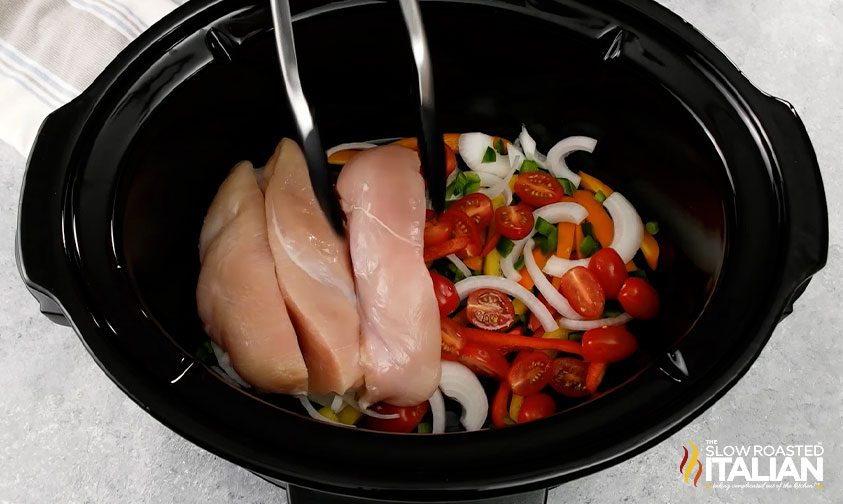 adding chicken breast to slow cooker for crock pot chicken fajitas