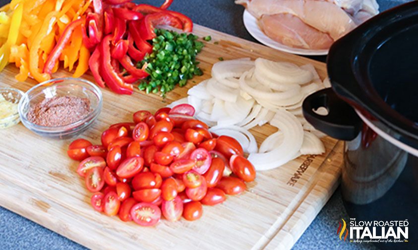 slices of white onion, red bell peppers and tomatoes on cutting board