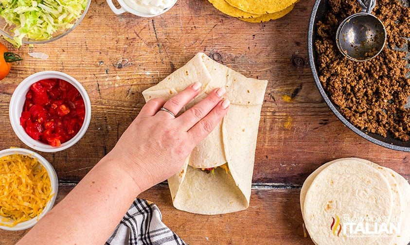 folding flour tortilla around corn tortilla