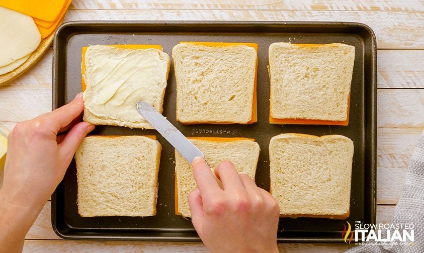 buttering slices of bread on sheet pan