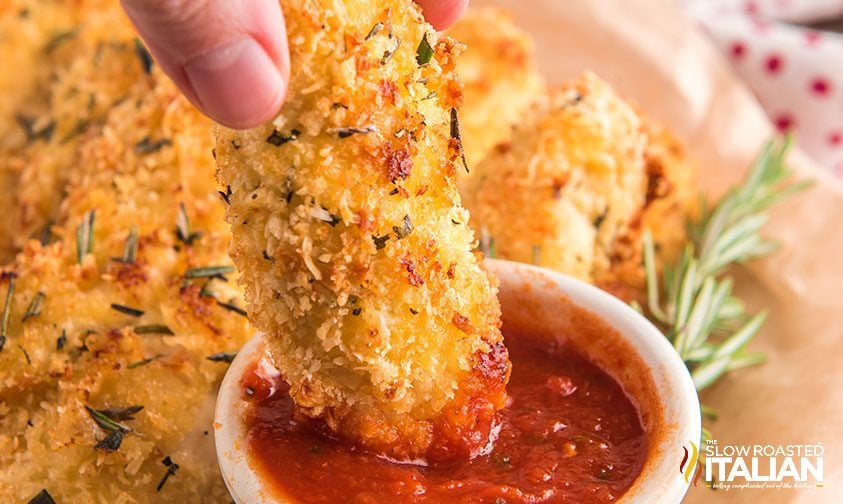 dipping breaded chicken into red sauce