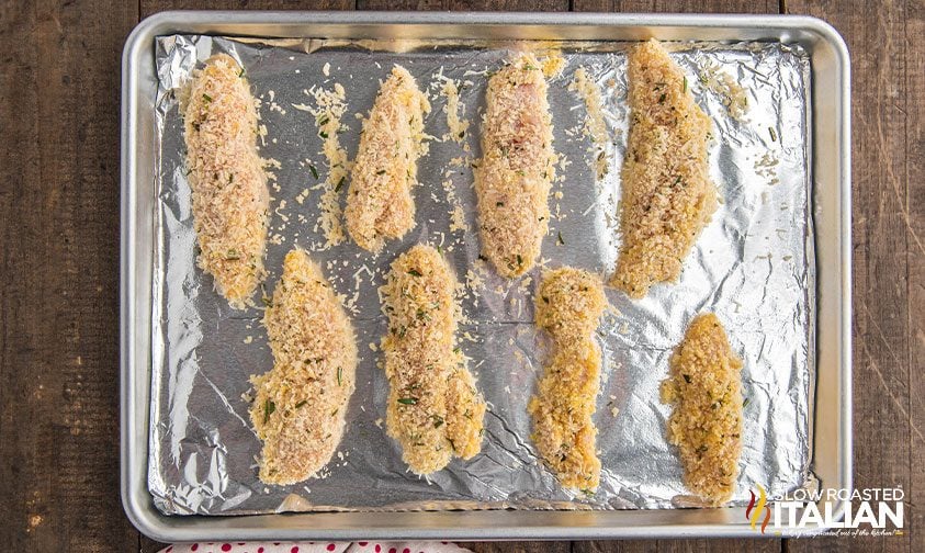 parmesan chicken tenders on foil-lined sheet pan, ready for baking