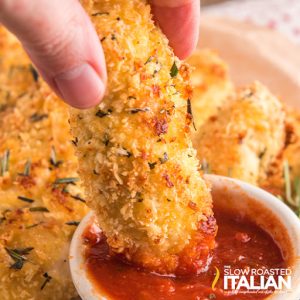 dipping breaded food into red sauce
