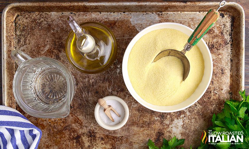 semolina flour in bowl next to olive oil, water and salt