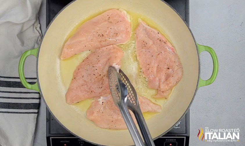 searing boneless skinless chicken breasts in skillet with oil