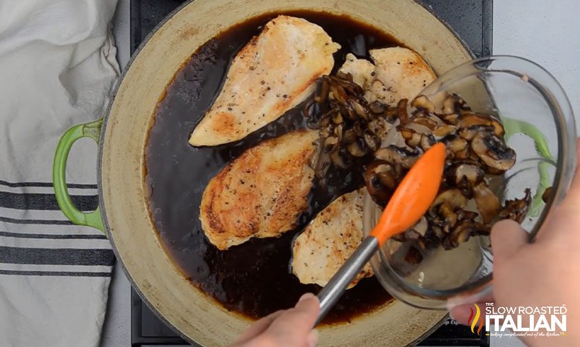 adding vegetables to skillet of chicken for chicken madeira recipe