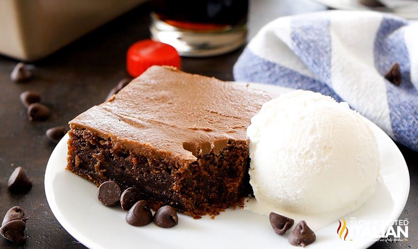 slice of coca cola cake on plate with scoop of vanilla ice cream