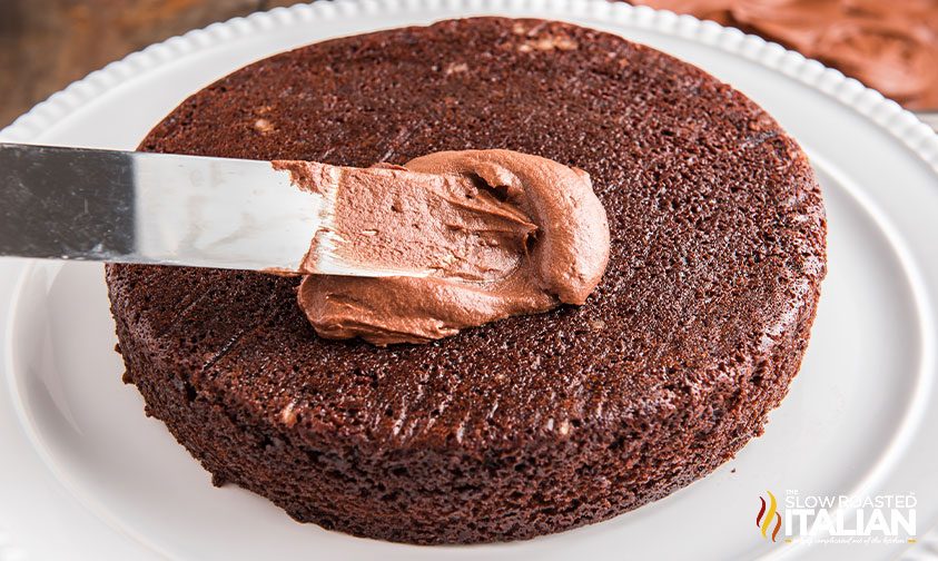 applying creamy frosting to a chocolaty dessert