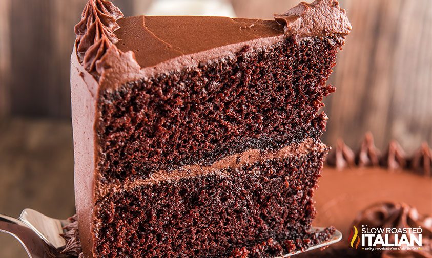 serving of frosted chocolate layer cake on cake server