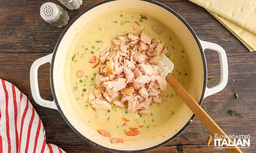 stirring shredded chicken into gravy