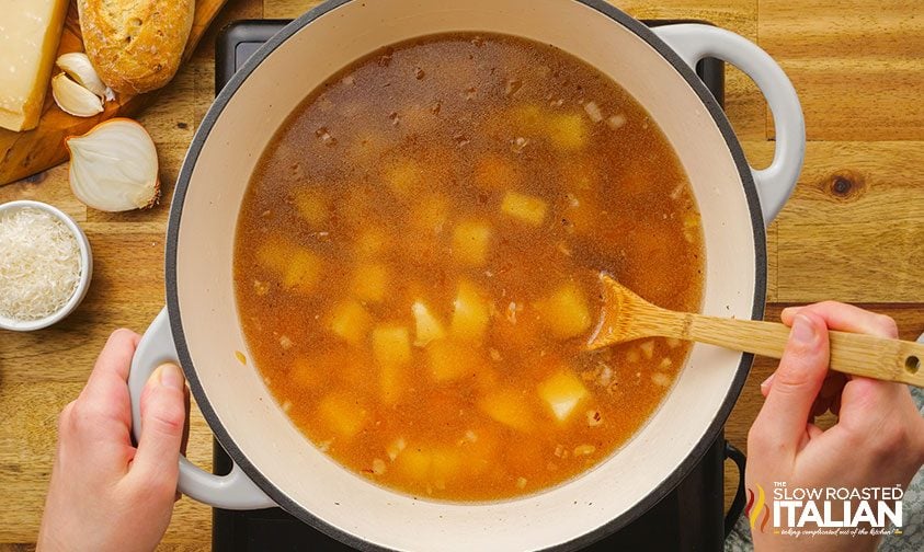 potatoes cooking in large pot of beef broth