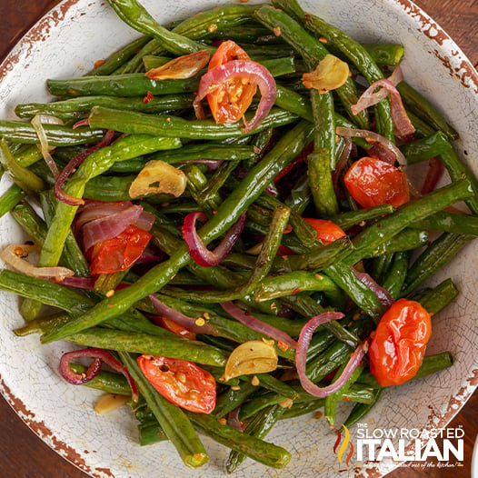 red onion, string beans and blistered tomatoes in bowl