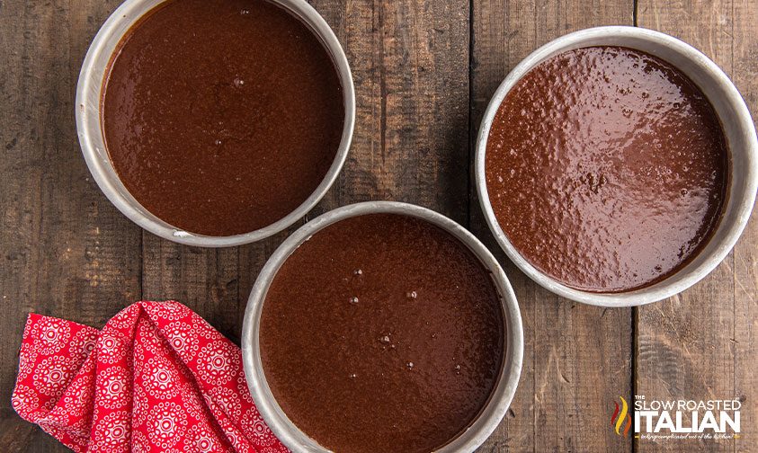 chocolate layer cake batter in 3 cake pans