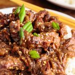 A plate of food with rice meat and vegetables, with Beef