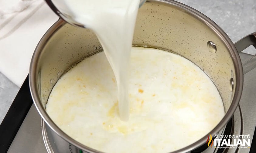 adding milk to saucepan for creamy cheese sauce