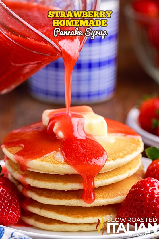 pouring strawberry pancake syrup on stack of buttered pancakes