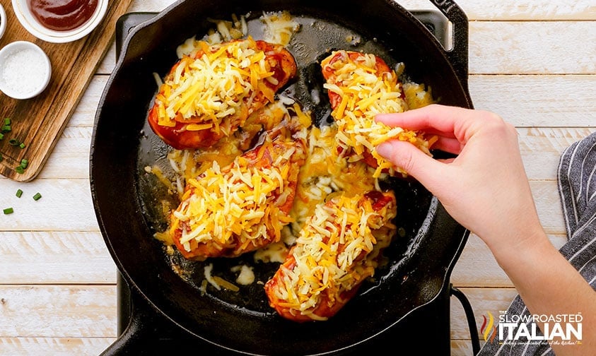 sprinkling shredded colby jack cheese over poultry in skillet