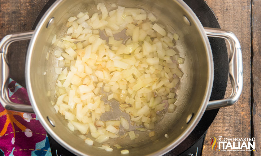 diced onions cooking in pot on stove