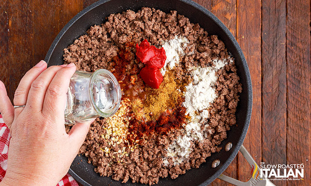 adding water to taco bell taco seasoning in skillet of ground beef