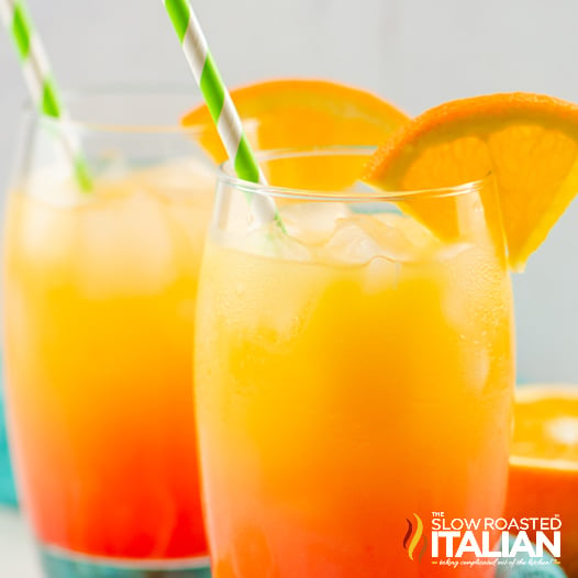 two tequila sunrise drinks in glasses with straws