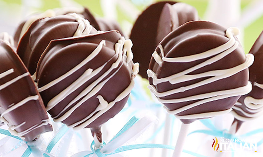 closeup: chocolate covered oreos with white frosting drizzle