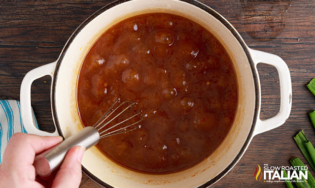 whisking asian orange sauce in dutch oven